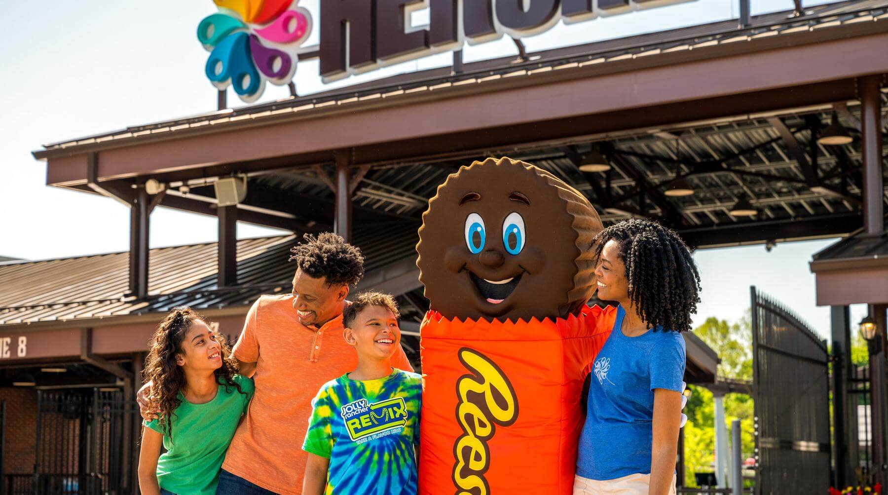 family posing with Reese character at Hersheypark