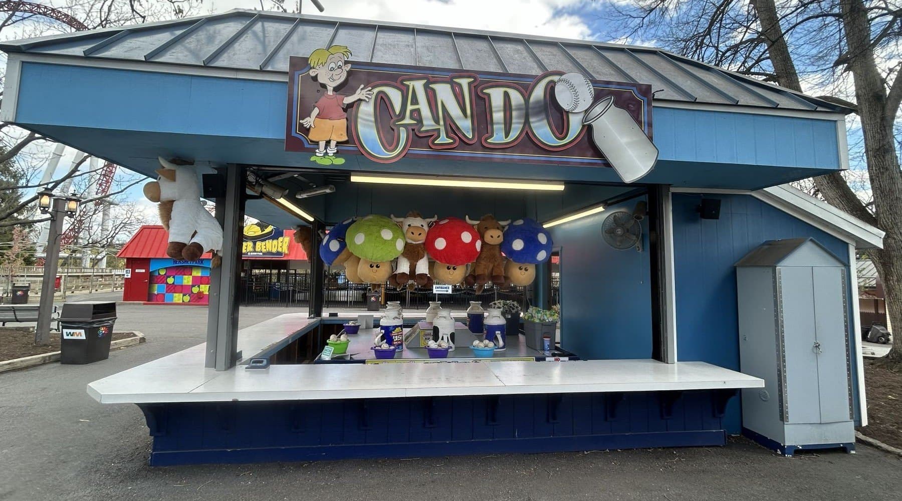 Players toss a softball and try to land it in the top of the milk can