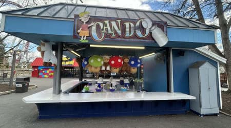 Players toss a softball and try to land it in the top of the milk can