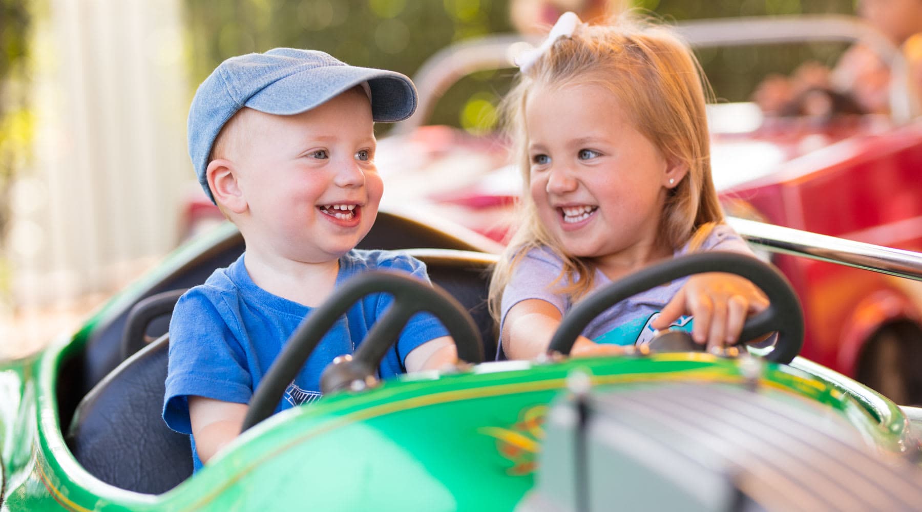 Children Smiling on Traffic Jam ride at Hersheypark as they pretend to drive a car