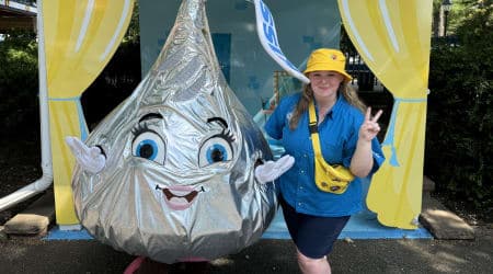 Hershey Team member posing with Miss Kiss outside of Hersheypark attraction