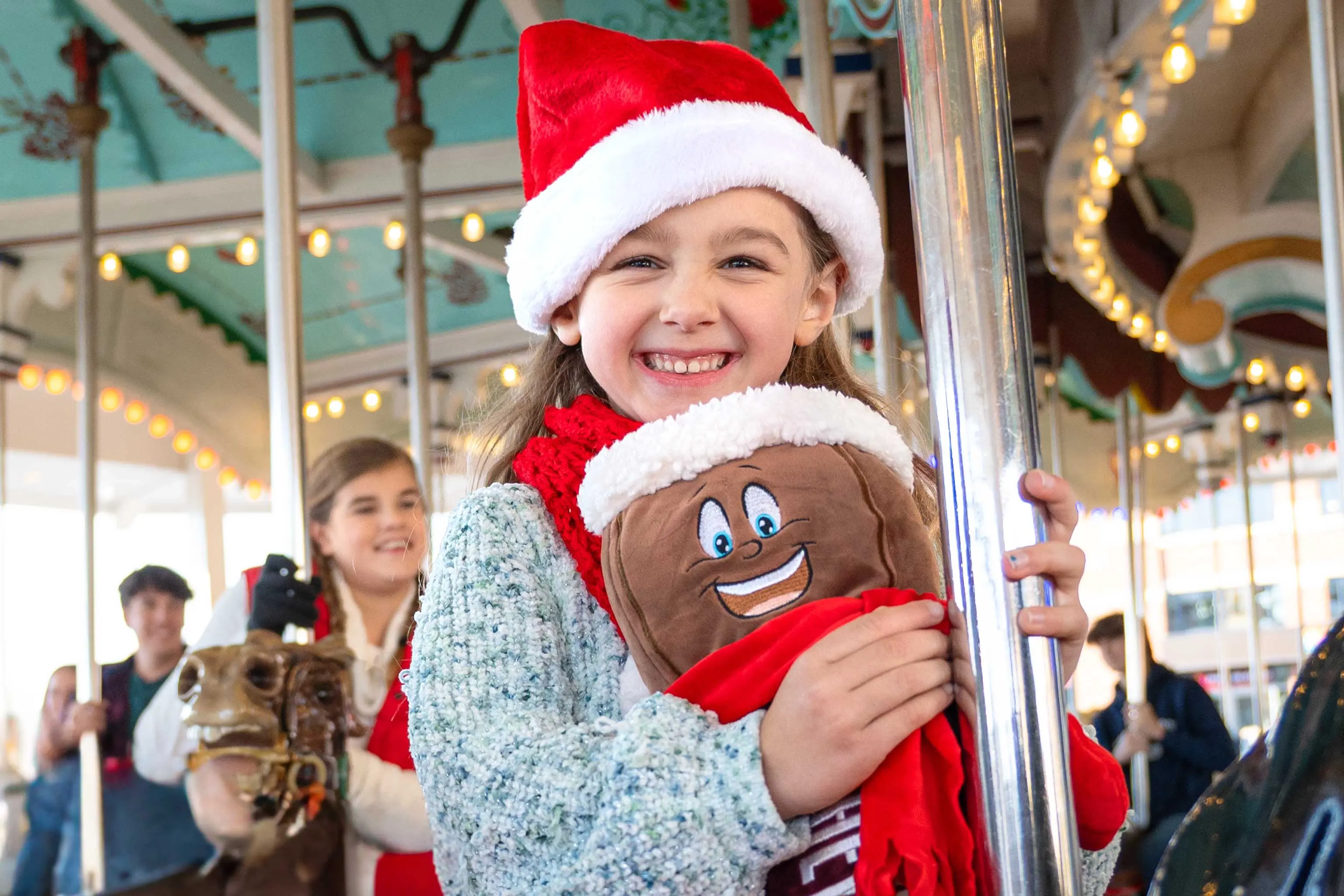23.HP.CCL.Carrousel.On Ride.Young Girl Smiling AT Camera.Santa Hat.Hershey Bar Plush