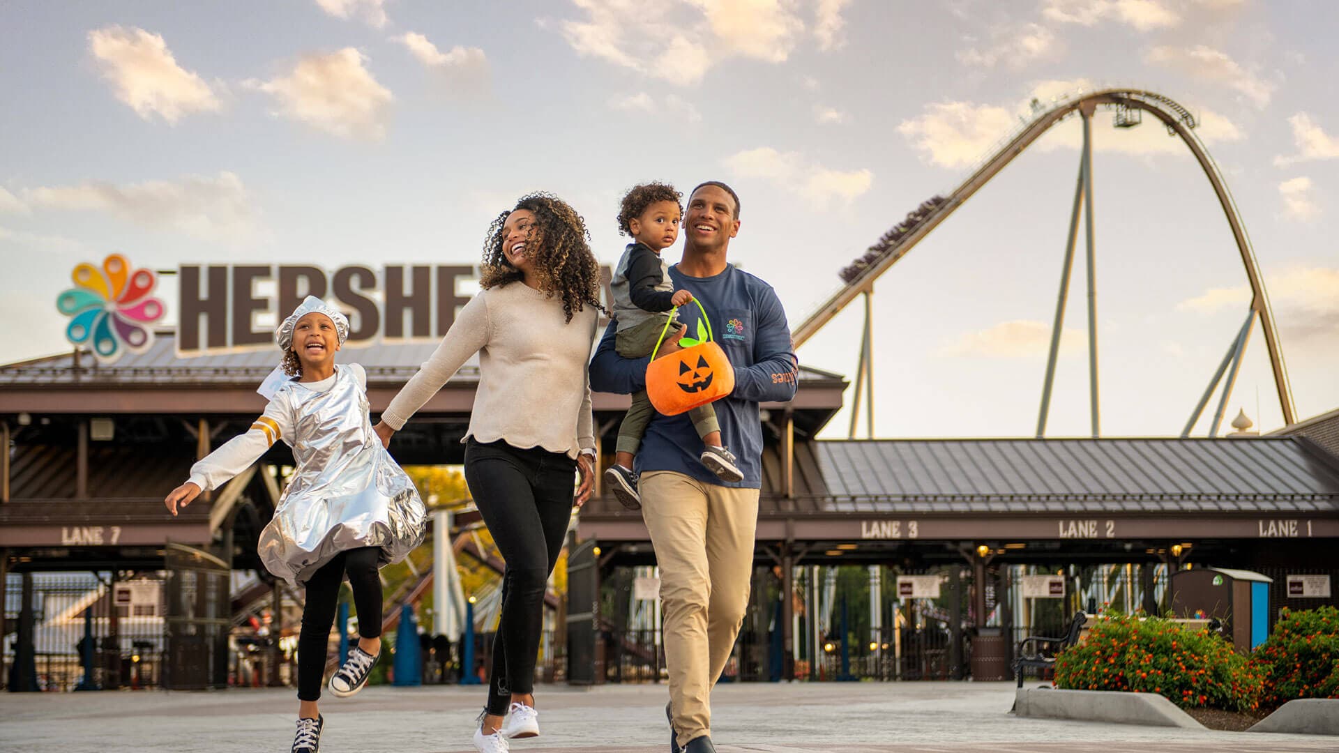 smiling family in front of hersheypark during hersheypark halloween