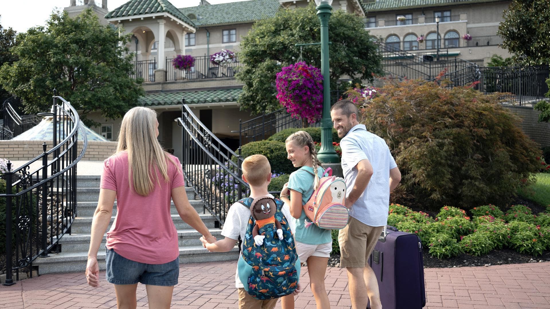 family carrying luggage to hotel hershey