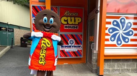 Reese Character in front of Reese's Cup House attraction.