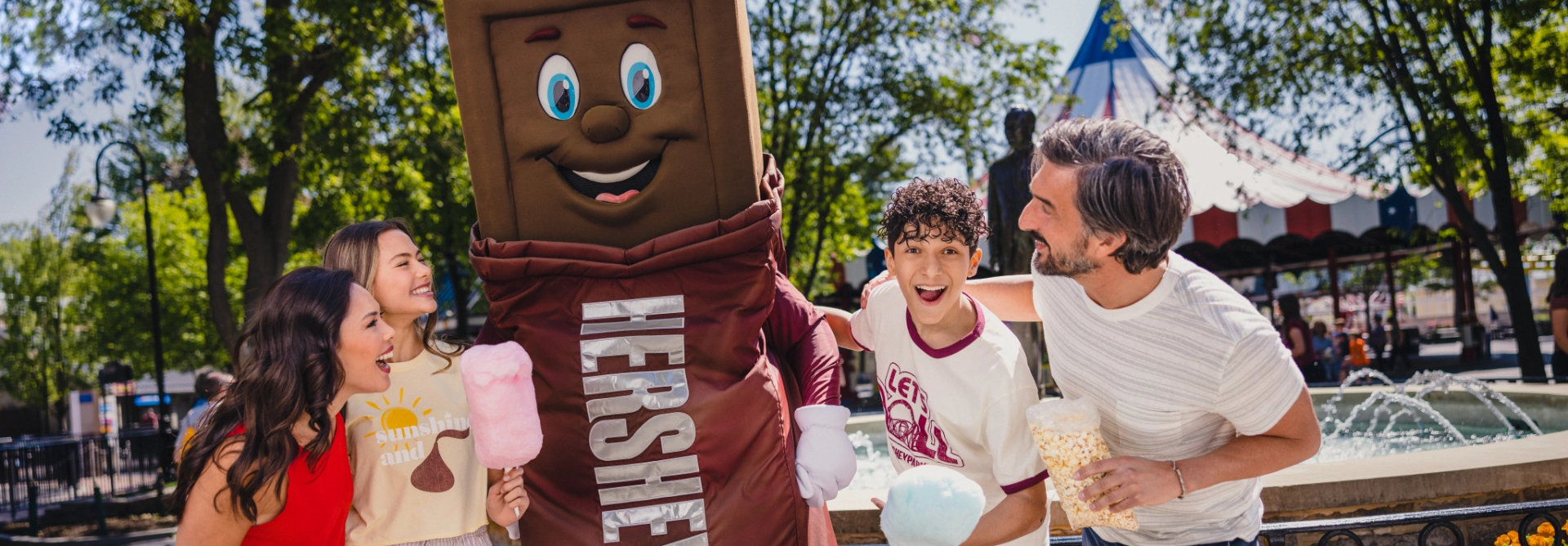 a family hanging out with the hershey mascots 