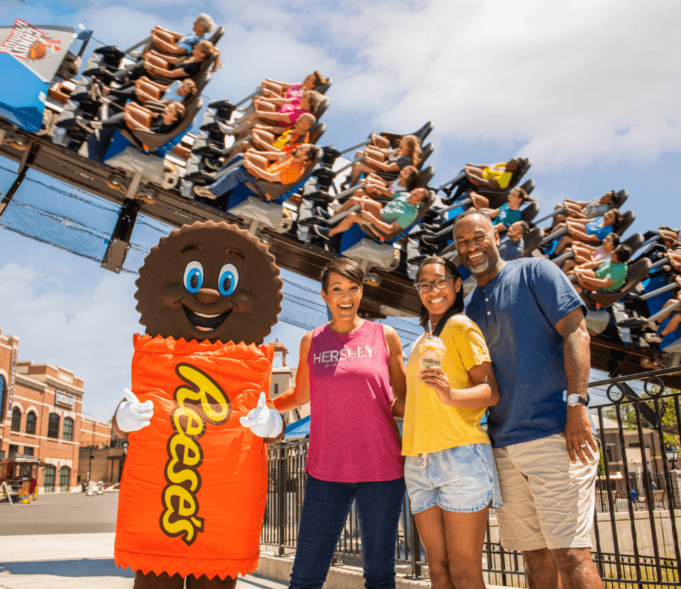 Family posing with Reese Character in front of Candymonium